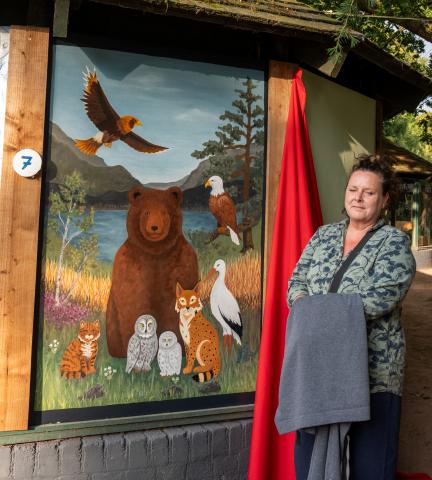 Artist, Lesley, standing beside her work 